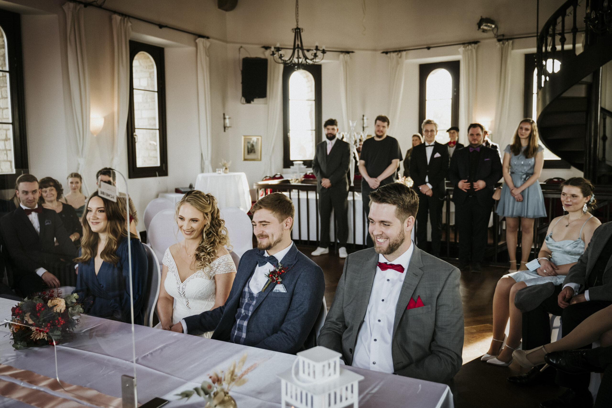 Menschen in festlichem Raum, formelle Kleidung, Lächeln, Teilnahme an Feier oder Zeremonie.
